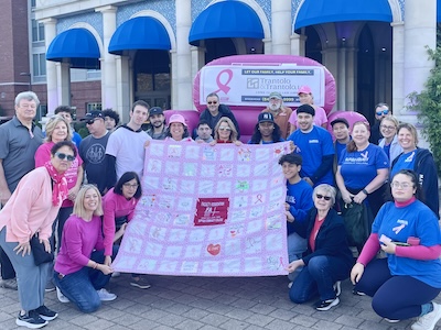 Team FA posing with breast cancer quilt at Making Strides event